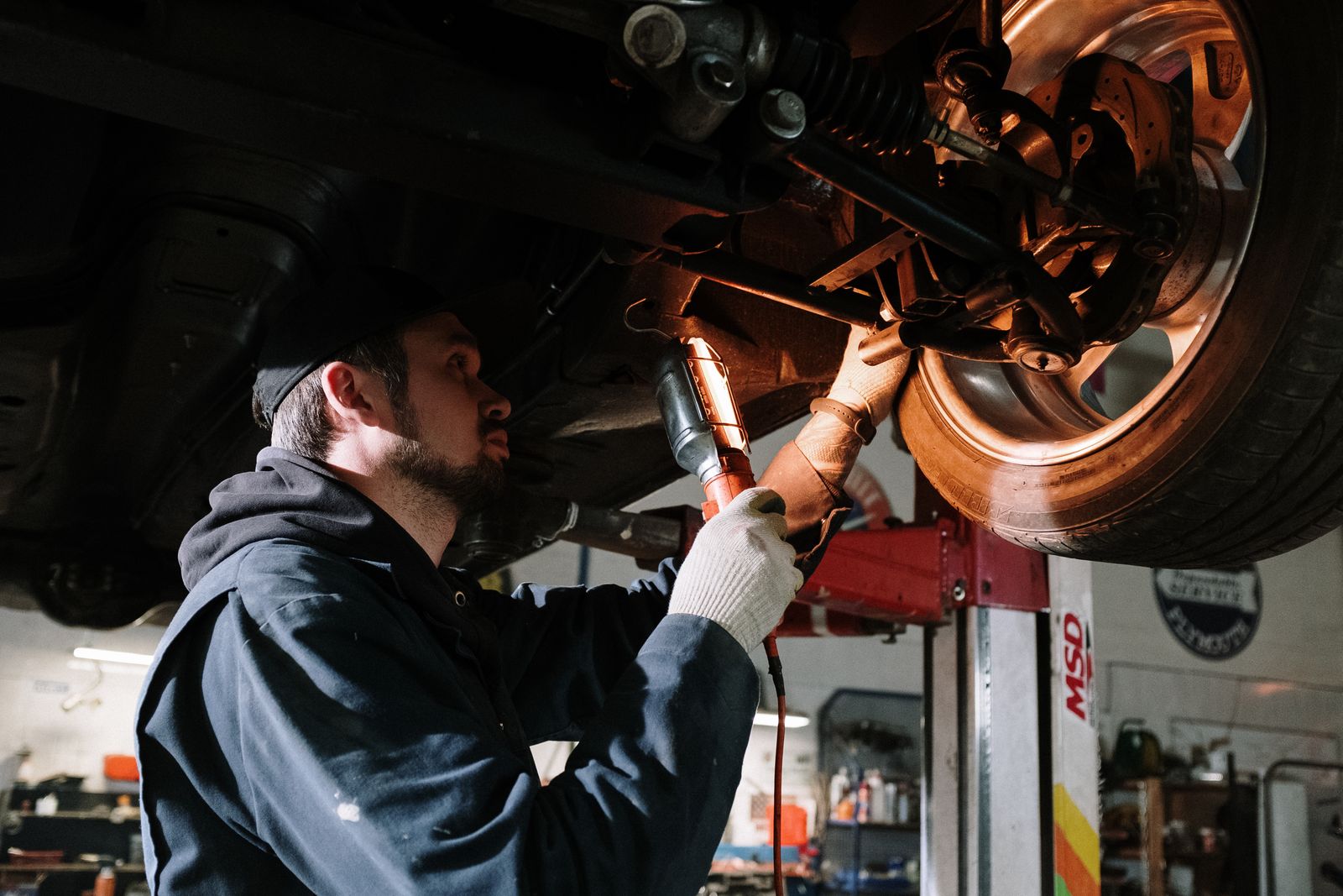 A mechanic working under a lift. Bay Two.