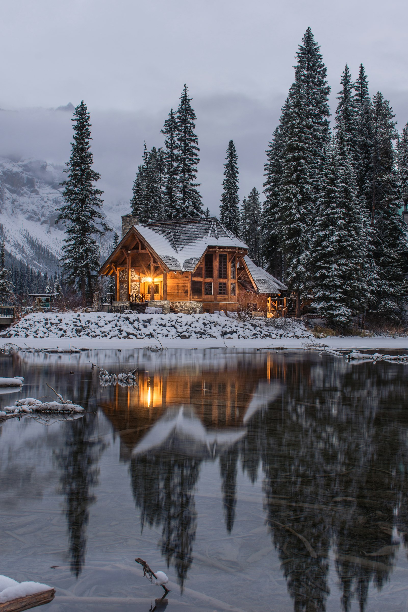 A cabin in the trees at dusk. Low Porch.