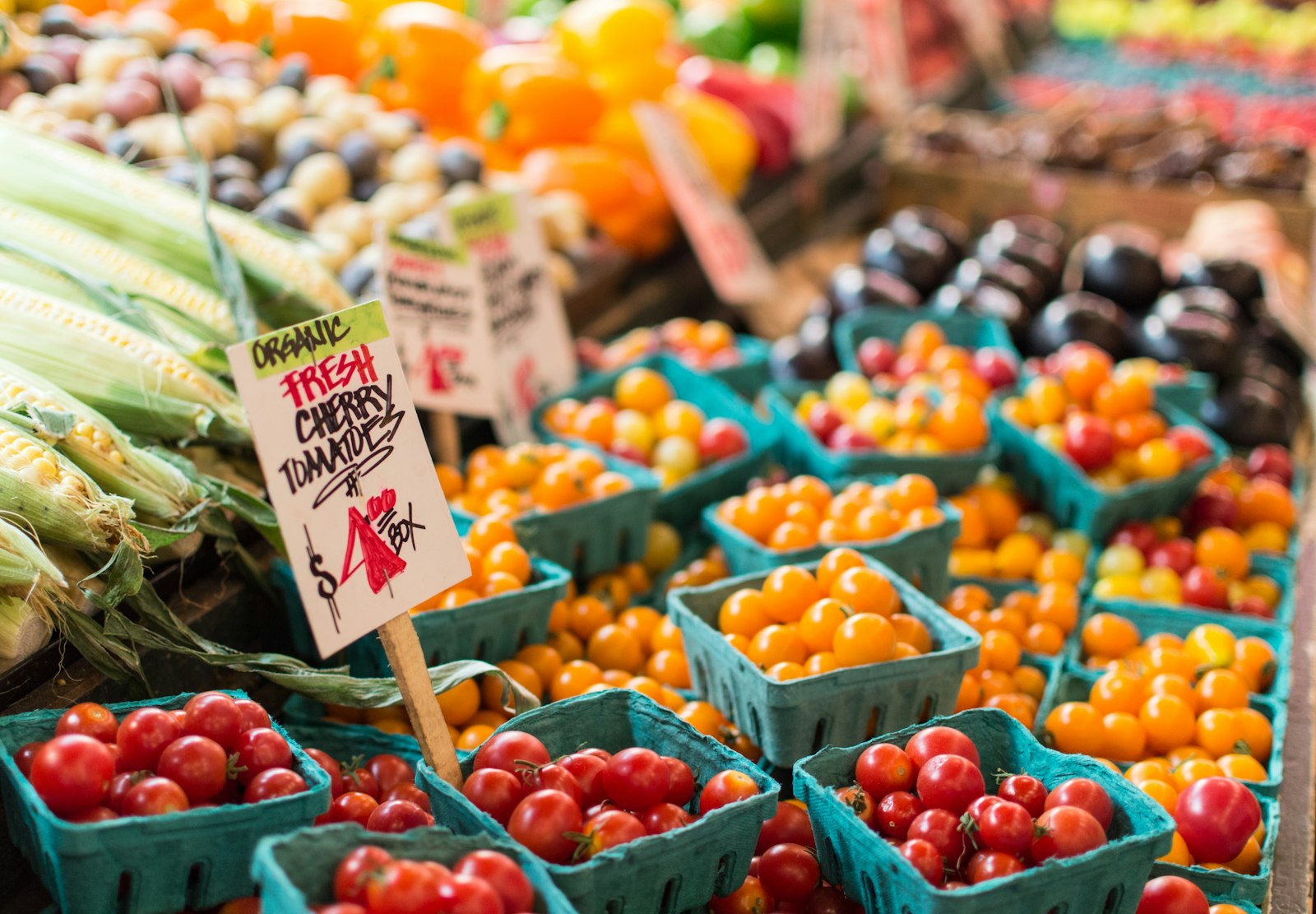 Cherry tomatoes in pint baskets and a handwritten price card. Paper Sack.