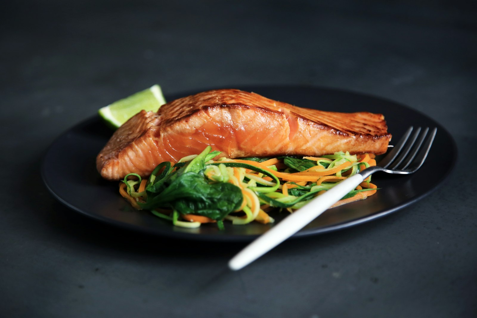 A cooked fish on a dark plate. Tide Line.