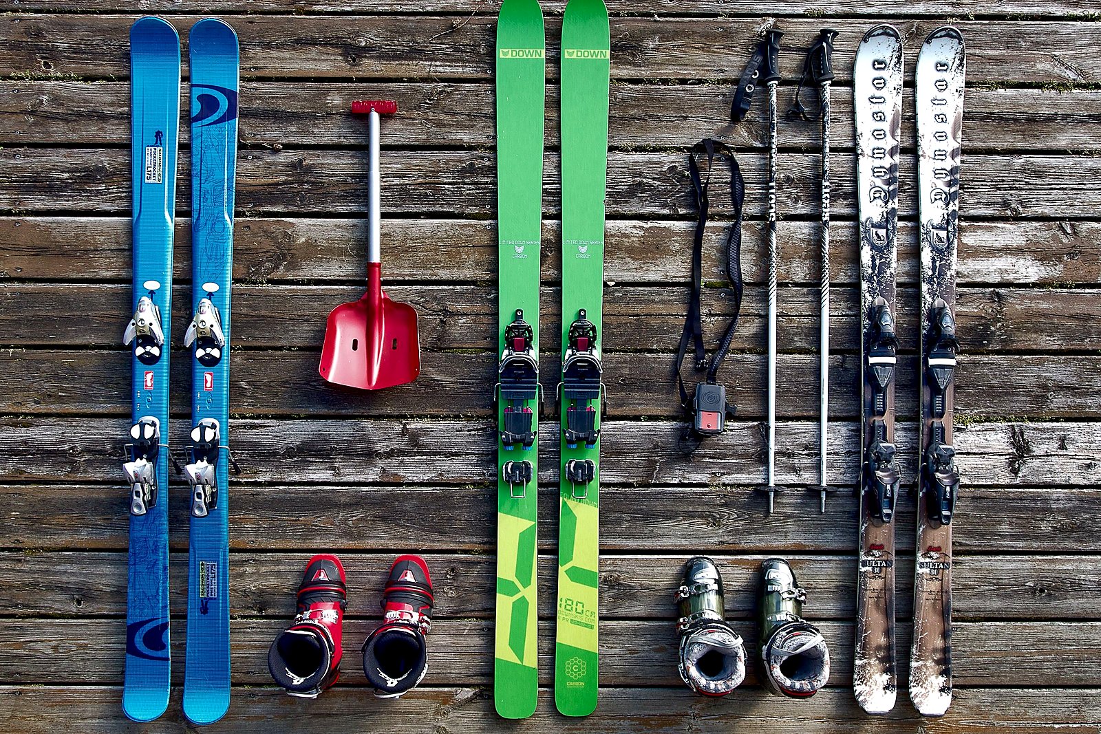 Ski and boot gear laid out across wooden boards on the shop floor.