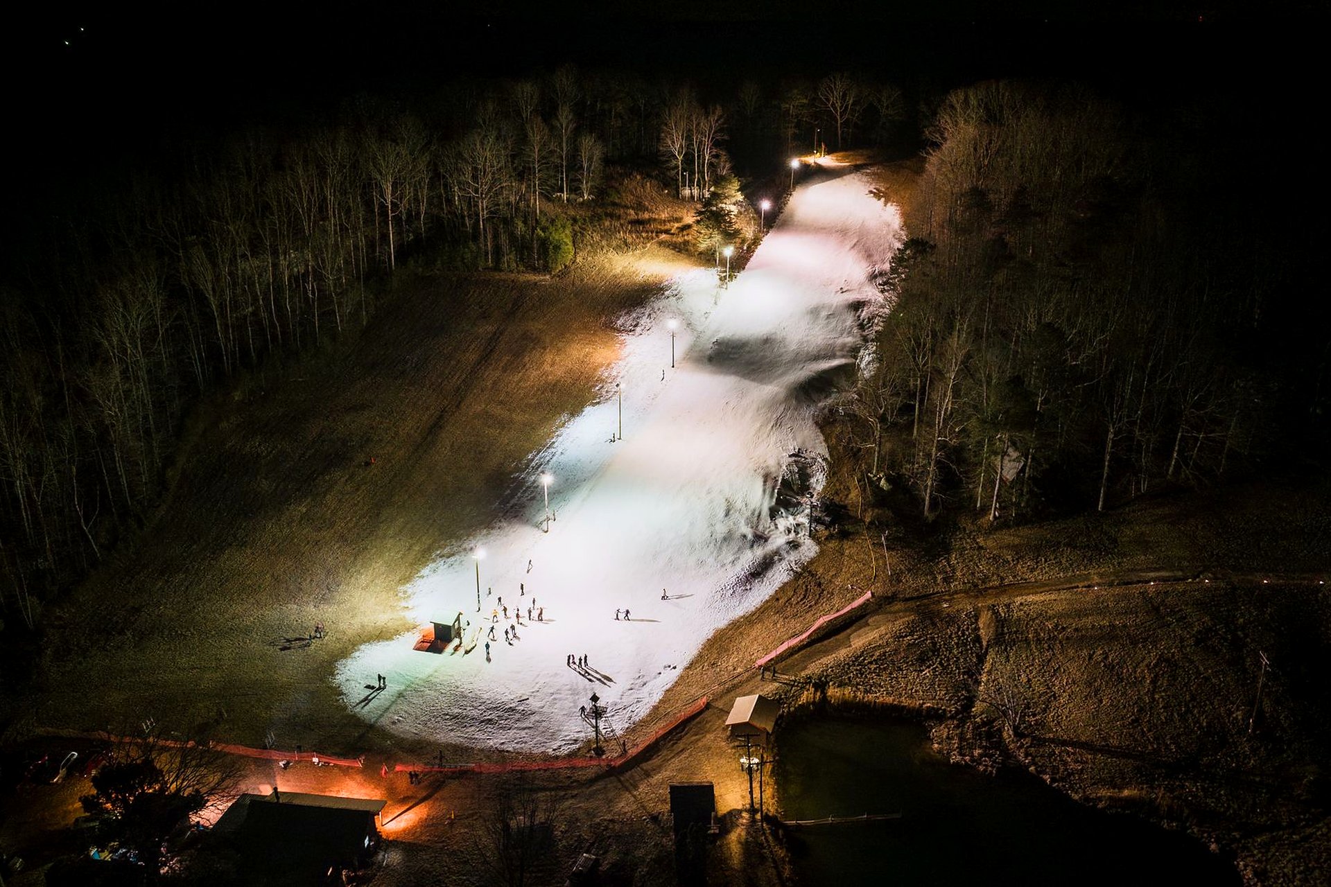 Night-lit ski slope with warm lodge glow at the base.